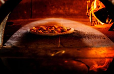 A pizza being cooked inside a pizza oven at a Mount Shasta Restaurant.